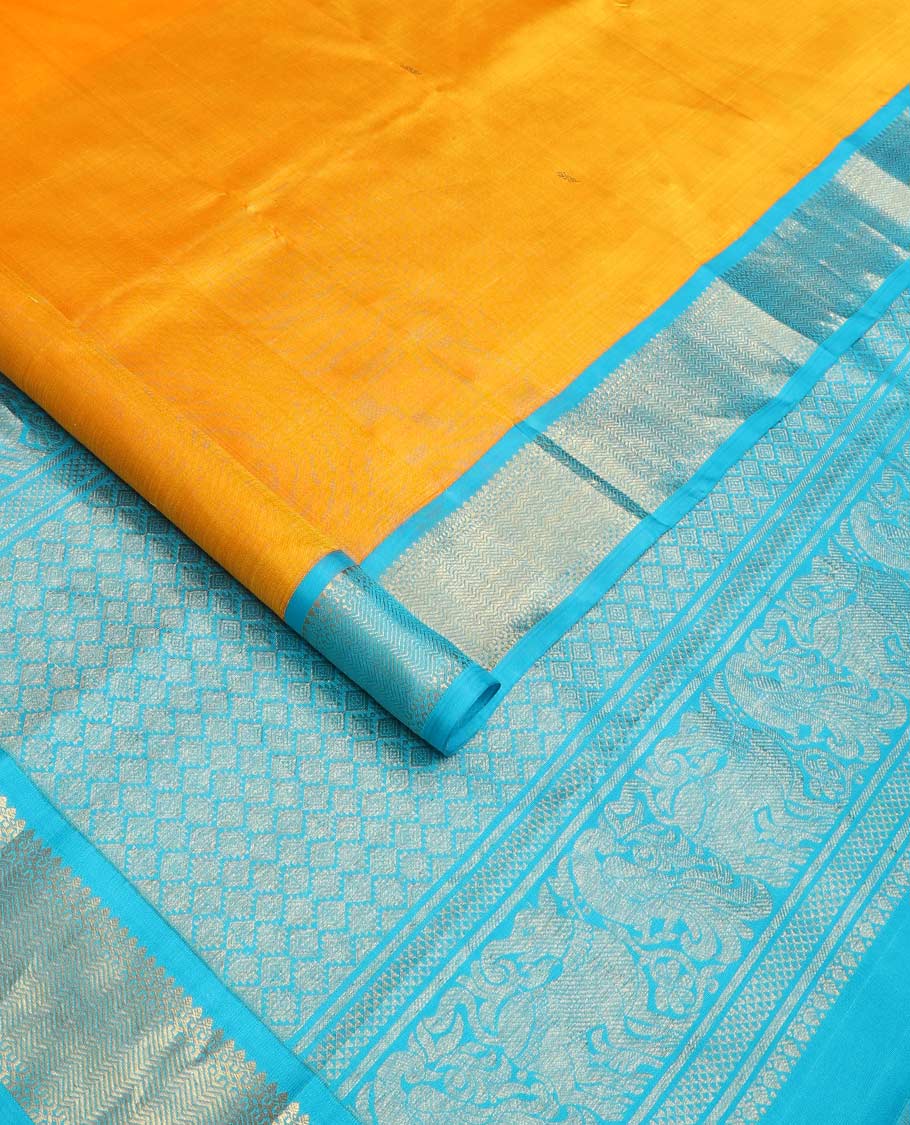 Yellow zari buttas Kanchipuram silk saree, contrast korvai border of thilakam mokku, muthu, and vanki designs, and zari-rich jaal pallu