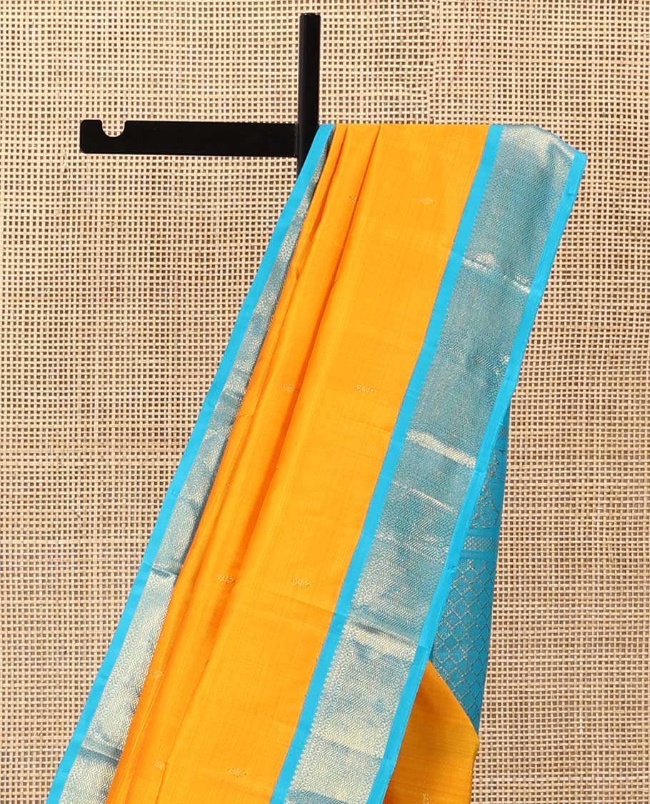 Yellow zari buttas Kanchipuram silk saree, contrast korvai border of thilakam mokku, muthu, and vanki designs, and zari-rich jaal pallu