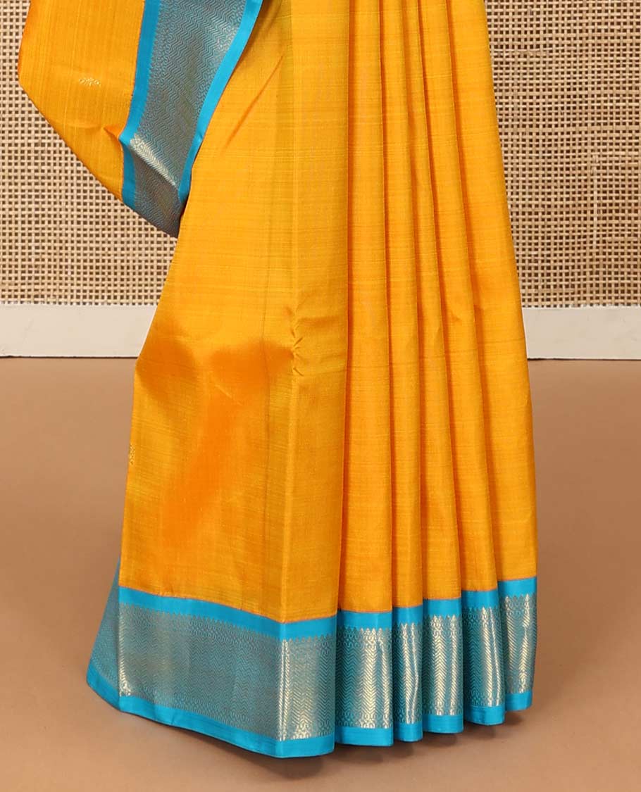 Yellow zari buttas Kanchipuram silk saree, contrast korvai border of thilakam mokku, muthu, and vanki designs, and zari-rich jaal pallu