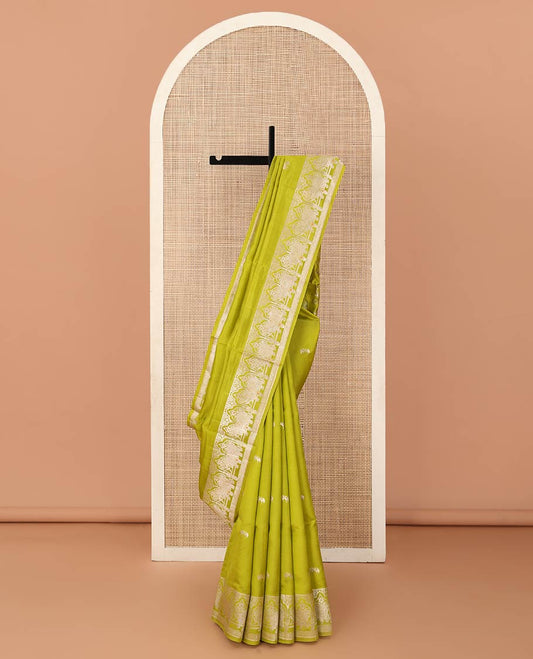 Parrot green zari buttas raw mango silk saree, Mughal border of elephant motifs, and pallu decked up with coconut tree, elephant, and butterflies