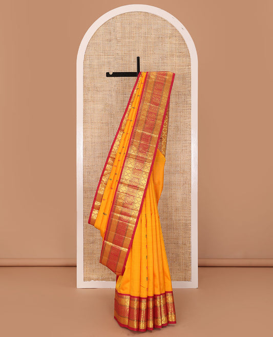 Yellow buttas Kanchipuram silk saree, contrast border of rudraksham, thazampoo rekku, arumbu manga, kathir, diamond, and mayil designs, and jaal pallu