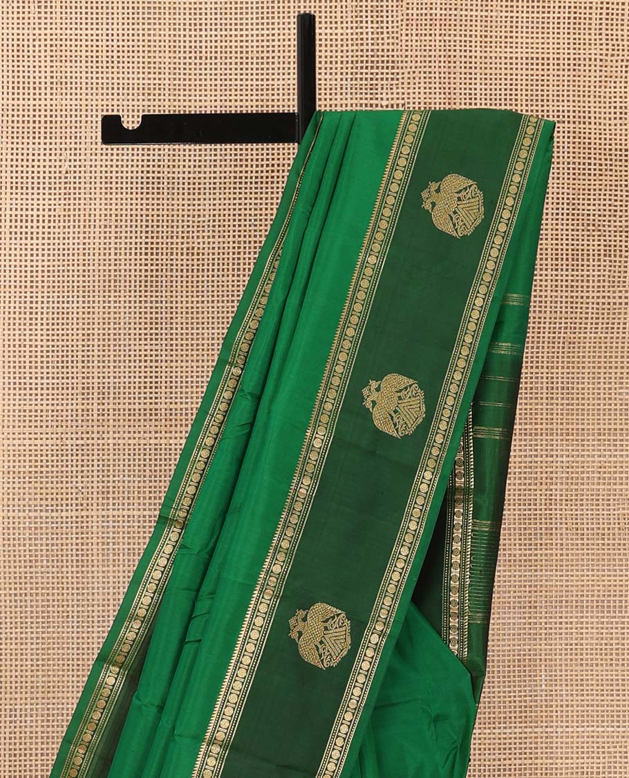 Green plain Kanchipuram silk saree, contrast border of rekku, muthu, rudraksham and iruthalai pakshi motifs, and zari striped pallu