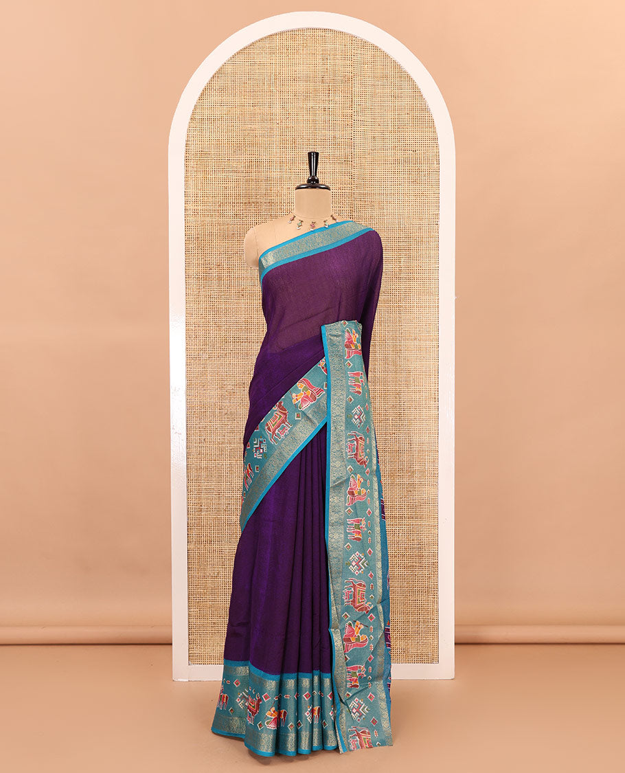 Violet embossed moss chiffon saree, contrast zari and colorfully printed border and pallu of human figurines and Pichwai cows, and embossed blouse