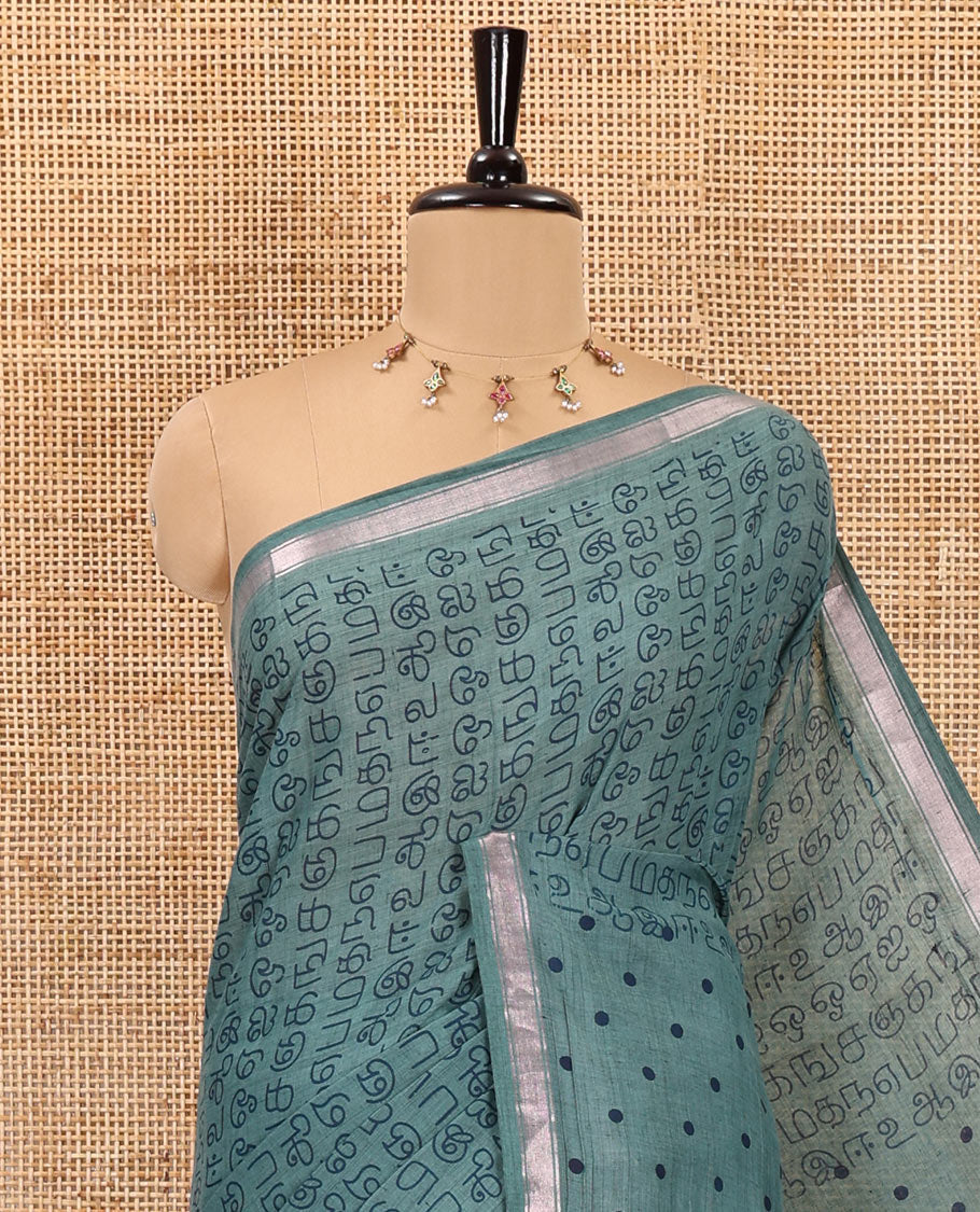 Green tamil letters printed soft cotton saree, zari piping border, small polka dotted pallu, and blouse of abstract and polka dots print