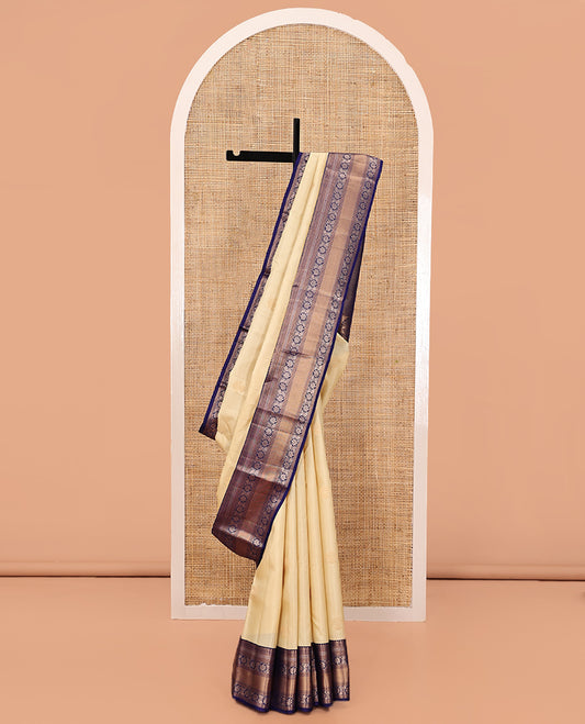 Sandal Vasundhara Silk Saree, Sparsely Sparkled with Zari Buttas, Complemented by a Contrast Border of Thilakam Mokku, Kodi Visiry, and Mayil Kann Designs, Jaal Pallu, and a Contrast Blouse