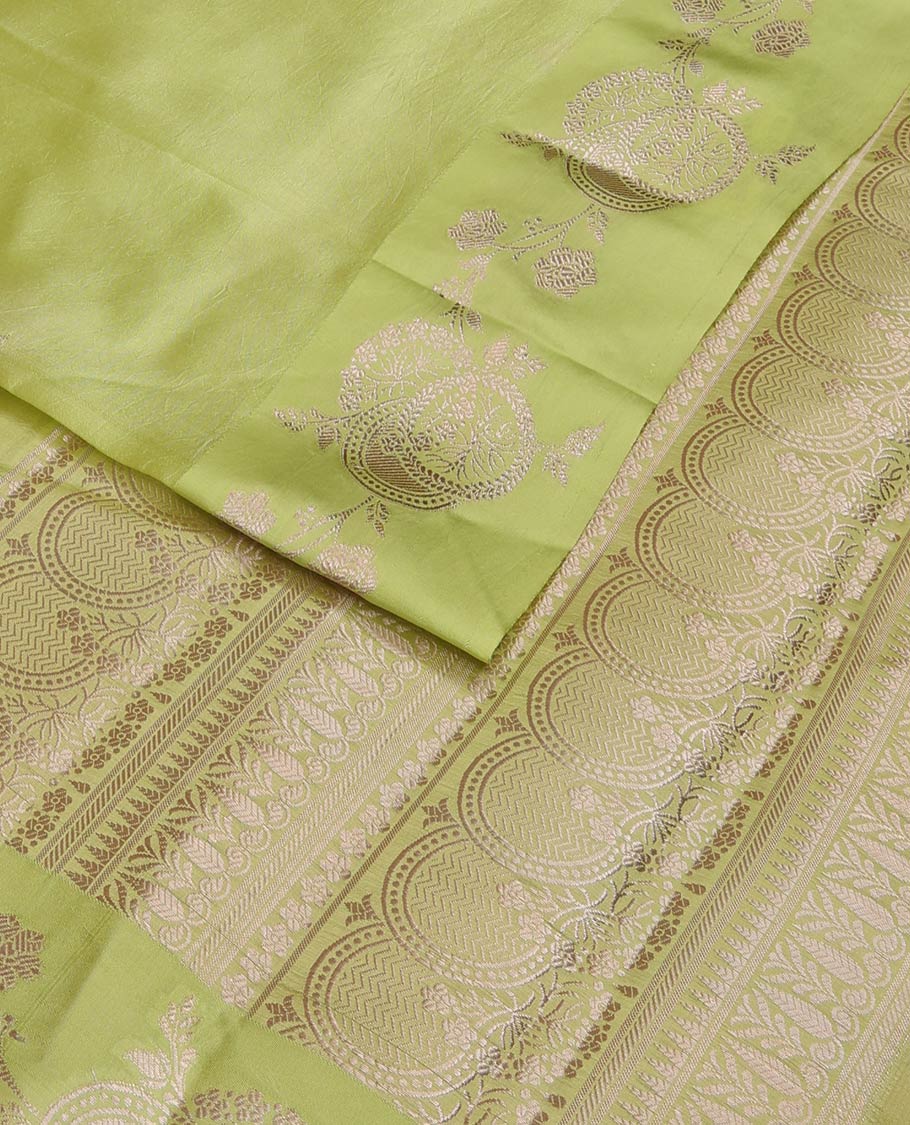 Green floral buttas raw mango silk saree, floral design border, and pallu adorned with floral, and geometric zari designs