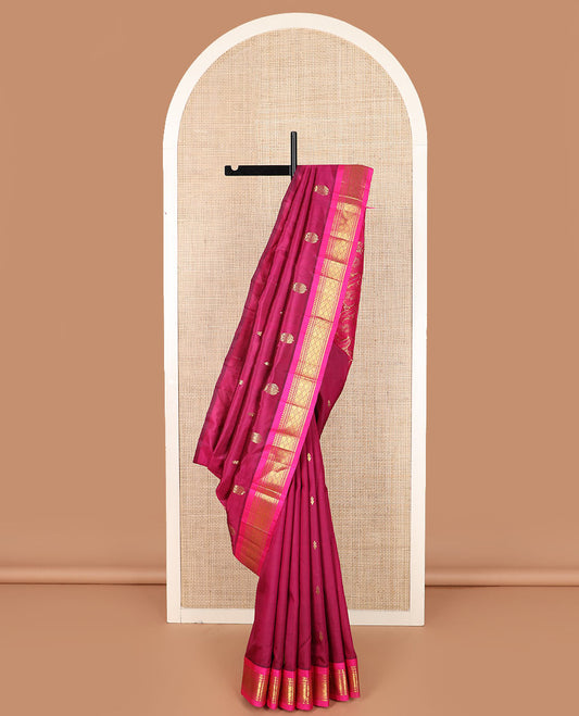 Maroon zari buttas Kanchipuram silk saree, contrast one-sided border of paneer sombu, banaras, muthu, and jaal designs, and pallu of floral designs