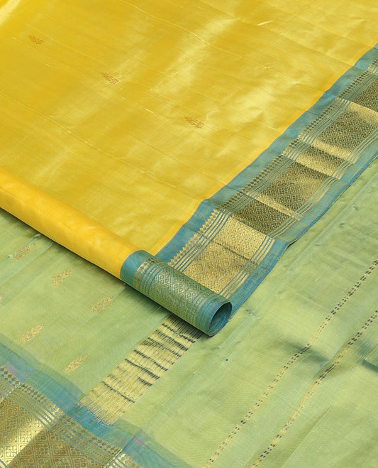 Yellow Kanchipuram silk saree with zari buttas, contrast one-sided border of panner sombu,banaras,muthu & jaal & zari design pallu