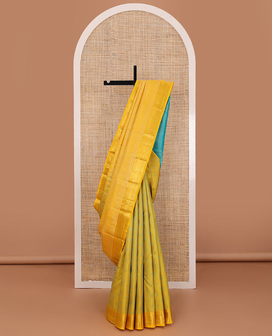 Yellow embossed silk saree, contrast border of thilakam mokku, muthu, ara bogudi, and kuyil kann, and jaal pallu