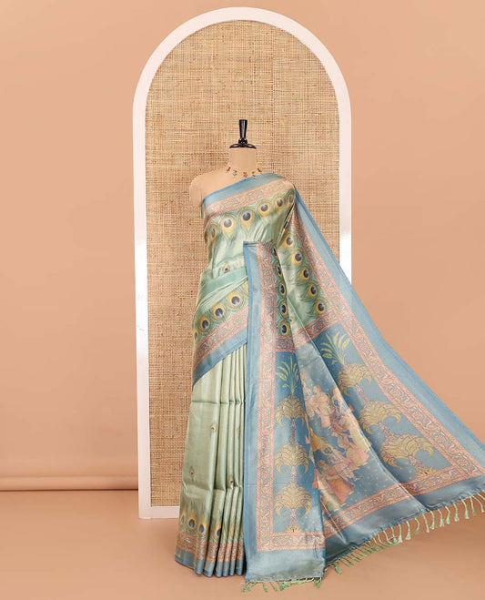 Peacock green peacock feather motifs printed tissue satin saree, contrast peacock motifs feather printed border, figurines printed pallu, and a contrast peacock motifs printed blouse