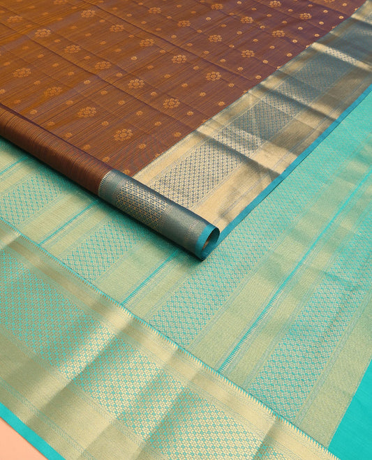 Brown Vasundhara Lite Silk Mix Saree Adorned with Zari Buttas, Complemented by a Contrast Border Featuring Ara Bogudi, Kathir, and Floral Designs, a Pallu Showcasing Floral Motifs, Paired with a Contrast Blouse