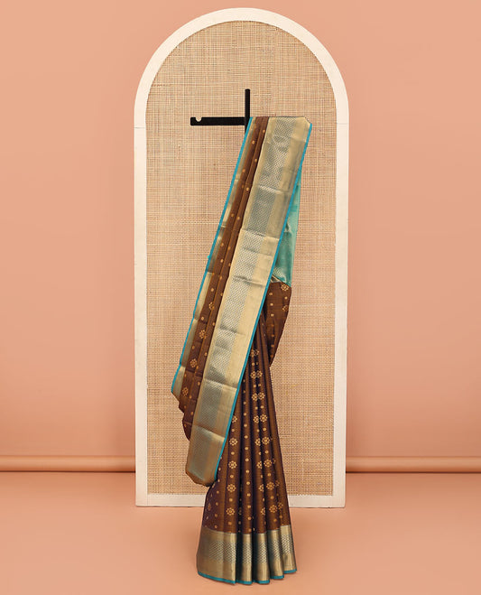 Brown Vasundhara Lite Silk Mix Saree Adorned with Zari Buttas, Complemented by a Contrast Border Featuring Ara Bogudi, Kathir, and Floral Designs, a Pallu Showcasing Floral Motifs, Paired with a Contrast Blouse