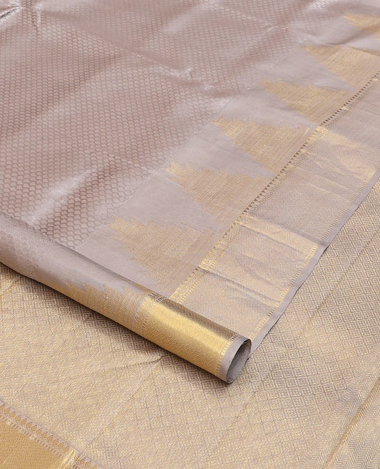 Grey embossed silk saree, thazampoo rekku golden zari border of thilakam mokku, muthu, and vanki designs, and zari rich jaal pallu