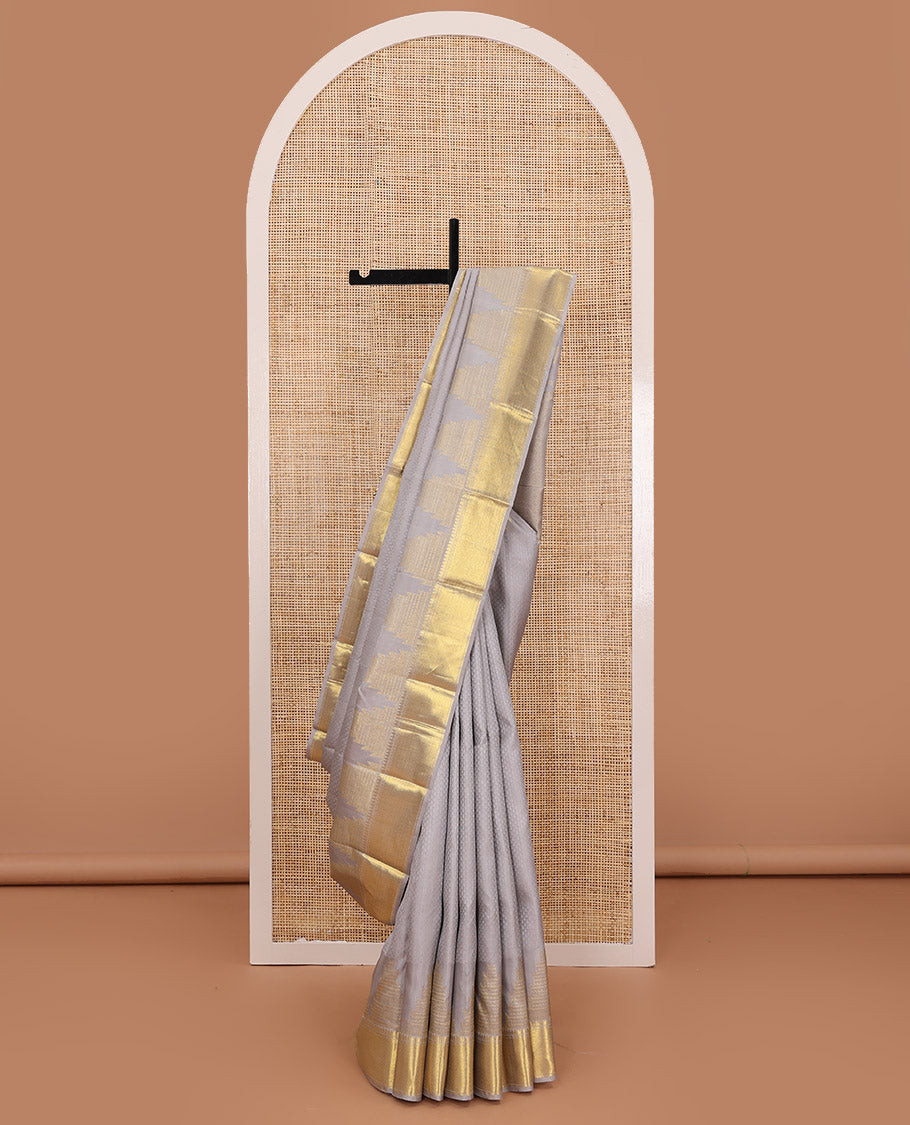 Grey embossed silk saree, thazampoo rekku golden zari border of thilakam mokku, muthu, and vanki designs, and zari rich jaal pallu