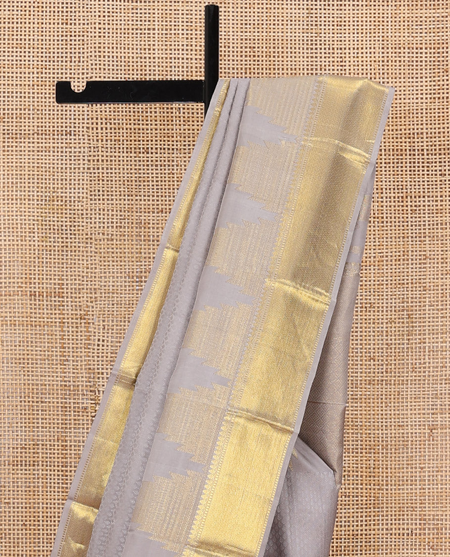 Grey embossed silk saree, thazampoo rekku golden zari border of thilakam mokku, muthu, and vanki designs, and zari rich jaal pallu