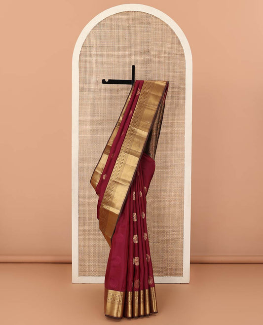 Maroon zari buttas Vasundhara silk mix saree, contrast border of thilakam, mayil kann, diamond, and manga designs, and geometric patterned pallu