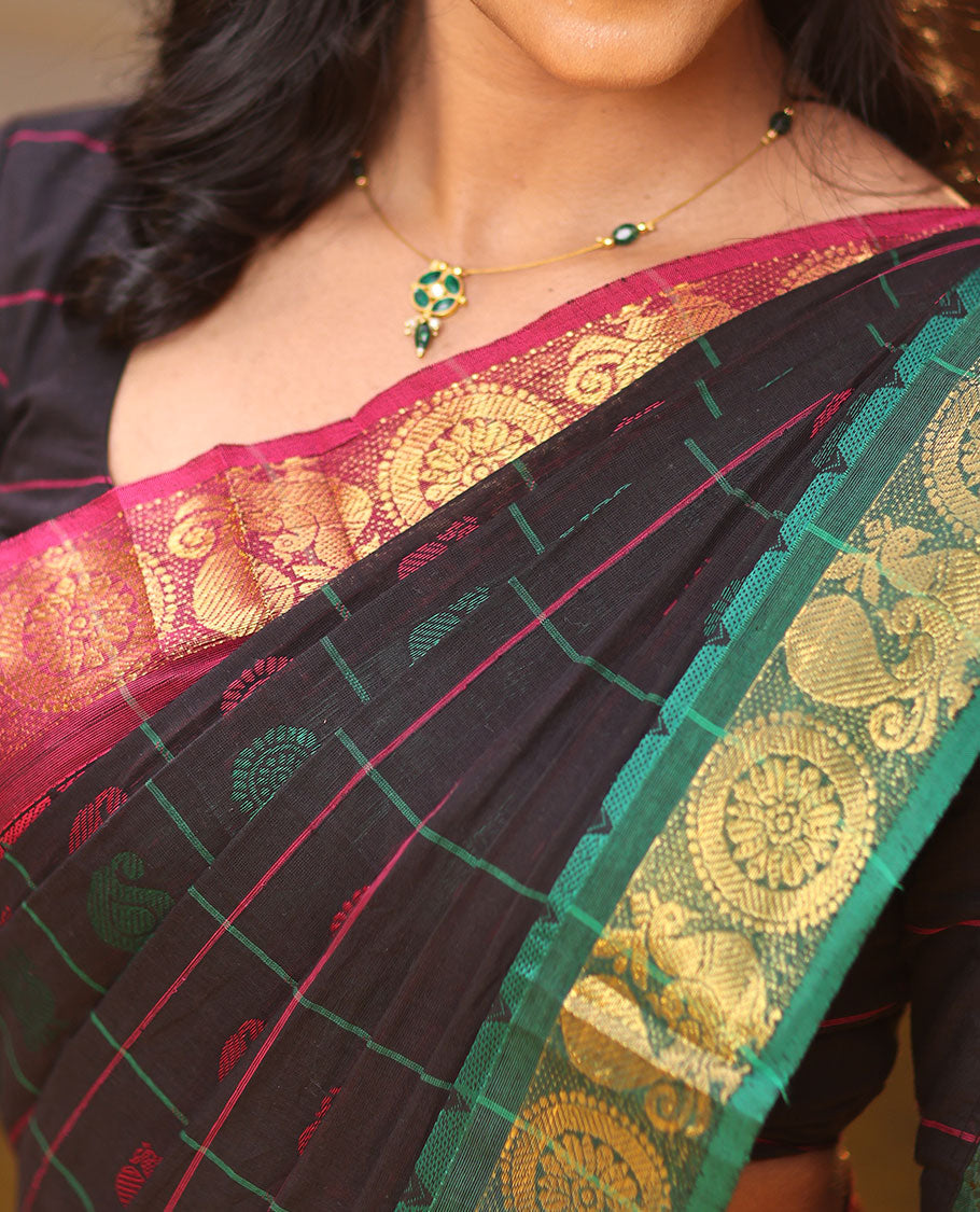 Black Chettinad Cotton Saree Features Butta Enclosed Checks, a Contrast Temple Annam-Peacock Ganga-Jamuna Border, and a Matching Blouse
