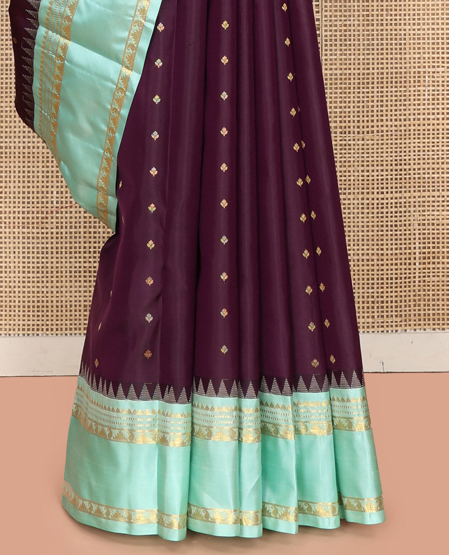 Purple Vasundhara Silk Saree, Spotlighted With Zari Buttas All Across Its Body, Complemented by Captivating Contrast Rettai Pettu Border of Thazampoo Rekku, Muthu, And Manga Designs, a Gleaming Zari Design Pallu, And Paired With a Contrast Blouse