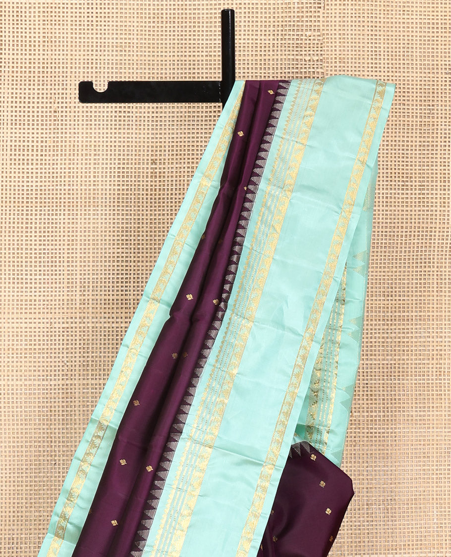 Purple Vasundhara Silk Saree, Spotlighted With Zari Buttas All Across Its Body, Complemented by Captivating Contrast Rettai Pettu Border of Thazampoo Rekku, Muthu, And Manga Designs, a Gleaming Zari Design Pallu, And Paired With a Contrast Blouse