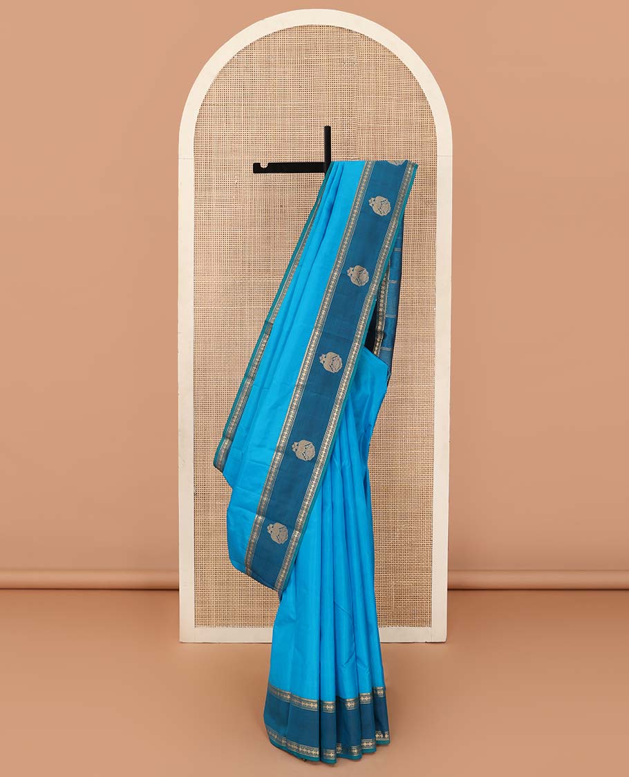 Blue plain Kanchipuram silk saree, contrast border of rekku, muthu, rudraksham and iruthalai pakshi motifs, and zari striped pallu