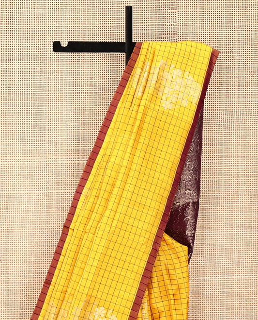 Yellow Mayuri Soft Silk Saree, Richly Detailed with Checks and Buttas All Over Its Body, Subtle Contrast Piping Border, Majestically Detailed Pallu of Leaf Designs, and Paired with a Contrast Blouse