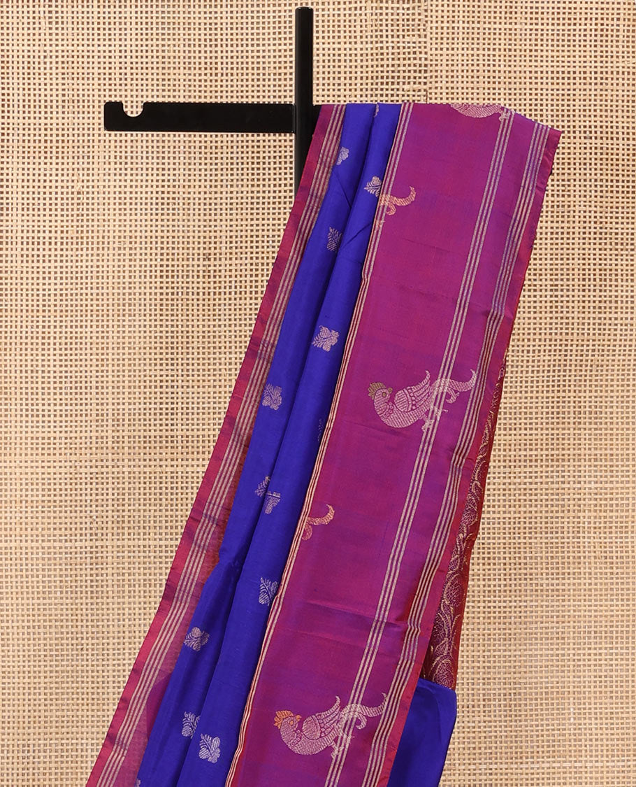 Blue Uppada Silk Saree Enlivened With Zari Buttas, Captivating Contrast Border Featuring Zari Stripes And Peacock Motifs, Pallu Depicting Rose Flower-Enclosed Mughal-Style Arches, And Paired With A Contrast Blouse