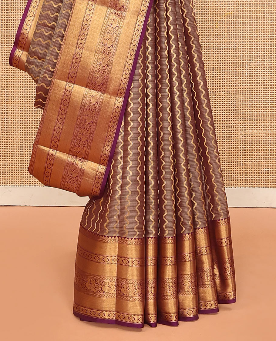 Brown Vasundhara Lite Silk Mix Saree Showcasing Zig-Zag Stripes Across the Body, Enhanced by a Contrast Border Adorned with Rekku, Puli Nagam, Laddu Kamalam, and Mayil Motifs, Complemented with a Zari-Woven Pallu and a Contrast Blouse