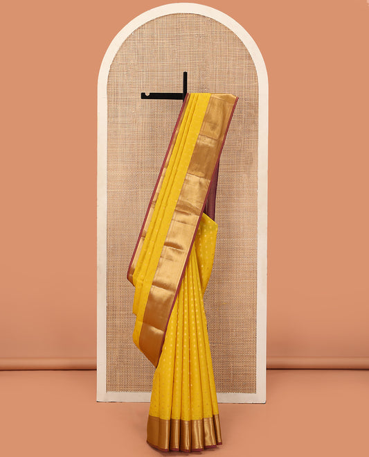 Yellow Vasundhara Lite Silk Mix Saree Decorated with Thilakam Buttas, Highlighted with Contrast Border Featuring Thilakam, Banaras, and Vanki Designs, Grandly Woven Pallu with Vanki Designs, and Paired with a Matching Blouse