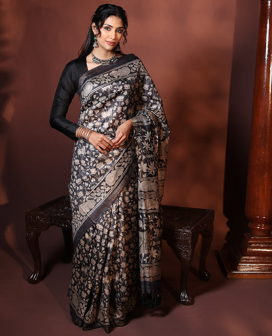 Black Tussar Saree Artfully Printed with Pichwai Cow and Lotus Motifs All Over Its Body, Subtly Made Self-Border of Kalamkari Floral-Peacock Print, Pallu Mirroring Pichwai Cow-Lotus Print, and Paired with a Plain Blouse