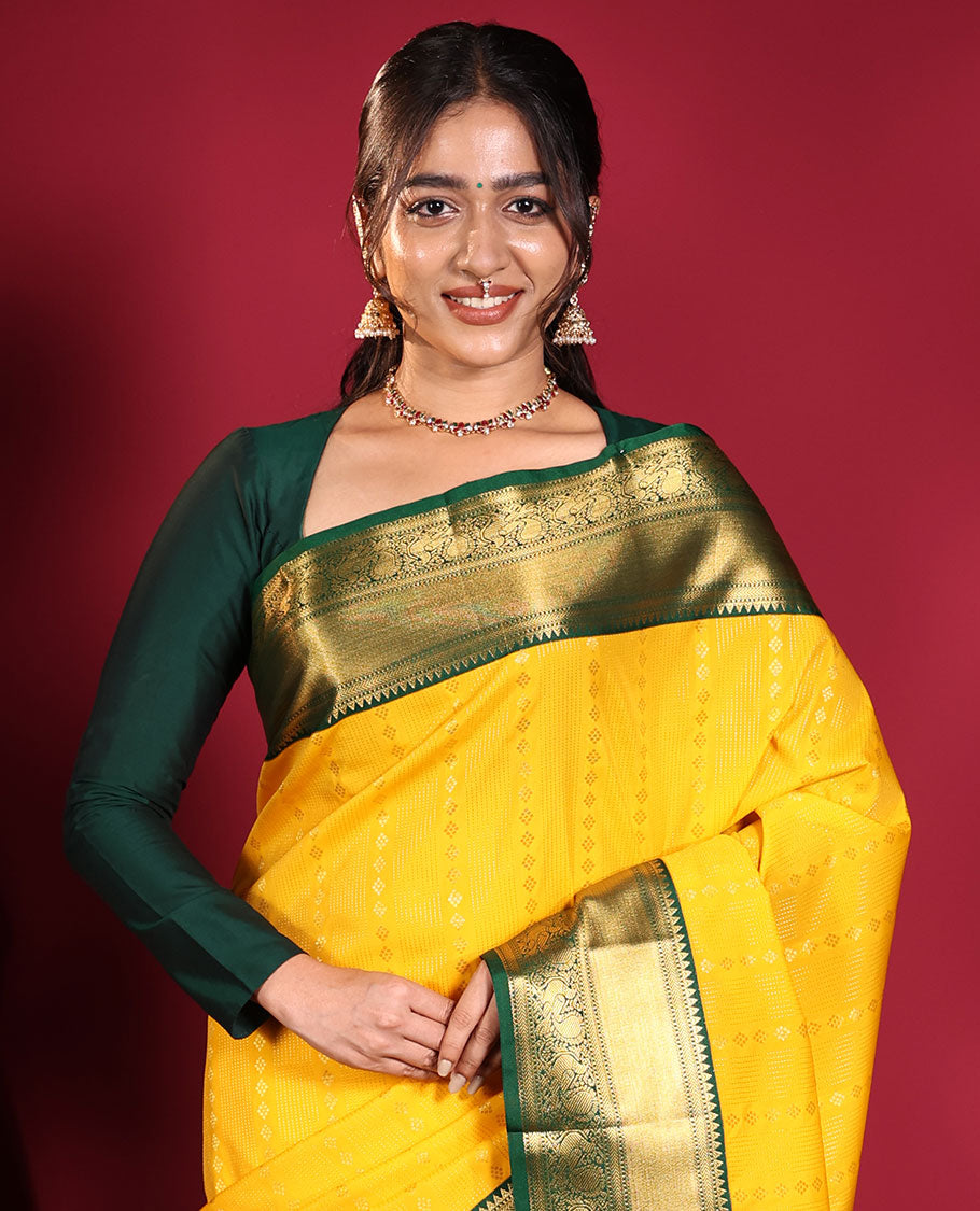 Yellow Budget Silk Saree, Richly Detailed with Zari Muthu, and Zari Buttas on Its Body, Complemented by a Contrast Traditional Zari Design Border of Peacock Designs, Gleaming Jaal Pallu, and Paired with a Contrast Blouse