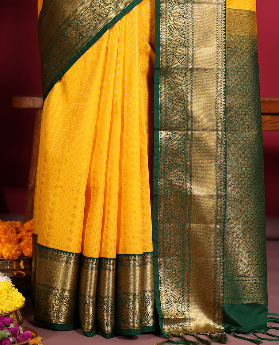 Yellow Budget Silk Saree, Richly Detailed with Zari Muthu, and Zari Buttas on Its Body, Complemented by a Contrast Traditional Zari Design Border of Peacock Designs, Gleaming Jaal Pallu, and Paired with a Contrast Blouse