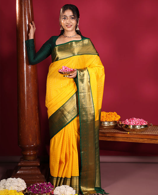 Yellow Budget Silk Saree, Richly Detailed with Zari Muthu, and Zari Buttas on Its Body, Complemented by a Contrast Traditional Zari Design Border of Peacock Designs, Gleaming Jaal Pallu, and Paired with a Contrast Blouse