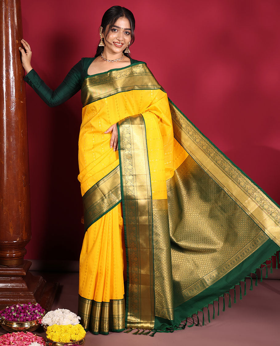 Yellow Budget Silk Saree, Richly Detailed with Zari Muthu, and Zari Buttas on Its Body, Complemented by a Contrast Traditional Zari Design Border of Peacock Designs, Gleaming Jaal Pallu, and Paired with a Contrast Blouse