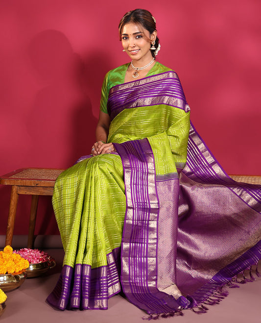 Green Vasundhara Silk Saree, Spotlighted with Zari Checked Design All Over Its Body, Complemented by a Contrast Varisai Pettu Border of Muthu, Poun, and Chakram Designs, Grandly Embellished Pallu of Jaal Designs, and Paired with a Contrast Blouse