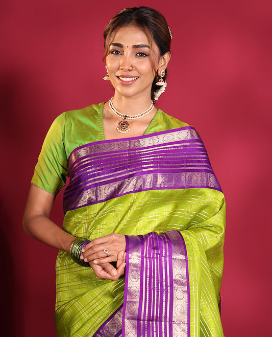 Green Vasundhara Silk Saree, Spotlighted with Zari Checked Design All Over Its Body, Complemented by a Contrast Varisai Pettu Border of Muthu, Poun, and Chakram Designs, Grandly Embellished Pallu of Jaal Designs, and Paired with a Contrast Blouse