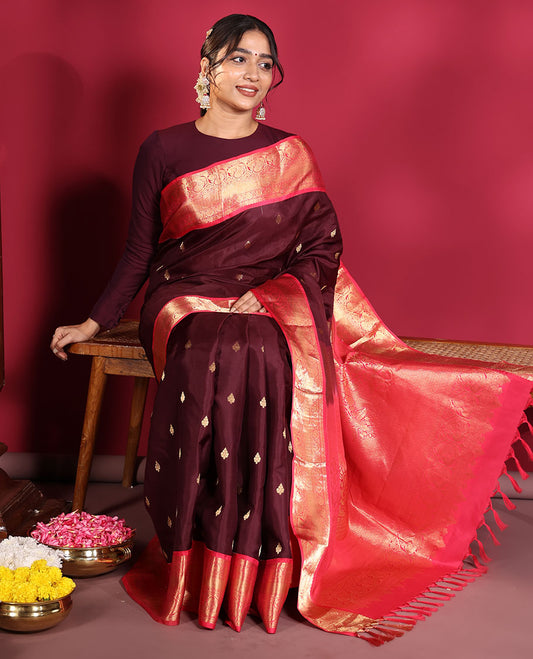 Brown Vasundhara Silk Saree, Decorated with Zari Buttas on Its Body, Complemented by a Contrast Traditional Zari Border of Mayil Designs, Grand Pallu Depicts Jaal and Floral Designs, and Paired with a Contrasting Blouse