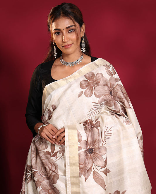 Cream Fancy Tussar Saree, Finely Detailed with Brownish Floral Motifs Printed on Its Body, Subtle Zari-Bavanji Border, Pallu Pictures Floral Print and Gleaming Zari Stripes, and Paired with a Matching Blouse