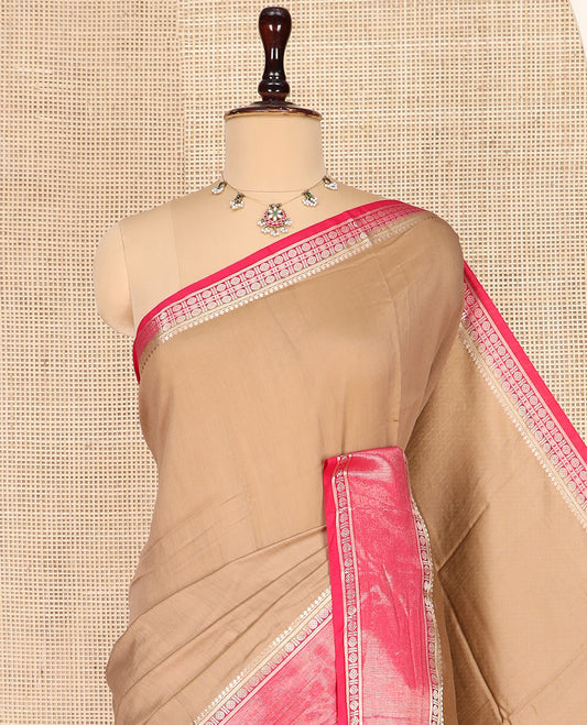 Light Brown Plain Assam Silk Saree, Complemented by a Contrast Traditional Zari Design Border of Rudraksha Motifs, a Gleaming Pallu of Zari Stripes, and Paired with a Contrast Blouse