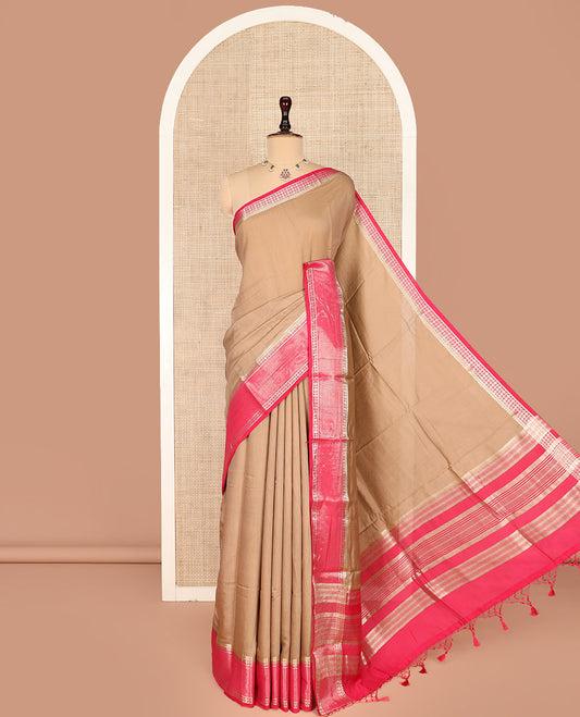 Light Brown Plain Assam Silk Saree, Complemented by a Contrast Traditional Zari Design Border of Rudraksha Motifs, a Gleaming Pallu of Zari Stripes, and Paired with a Contrast Blouse
