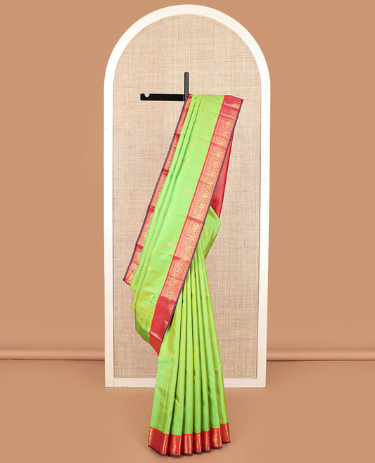 Green zari buttas Kanchipuram silk saree, contrast korvai border of thilakam mokku, muthu, and mayil designs, and jaal pallu