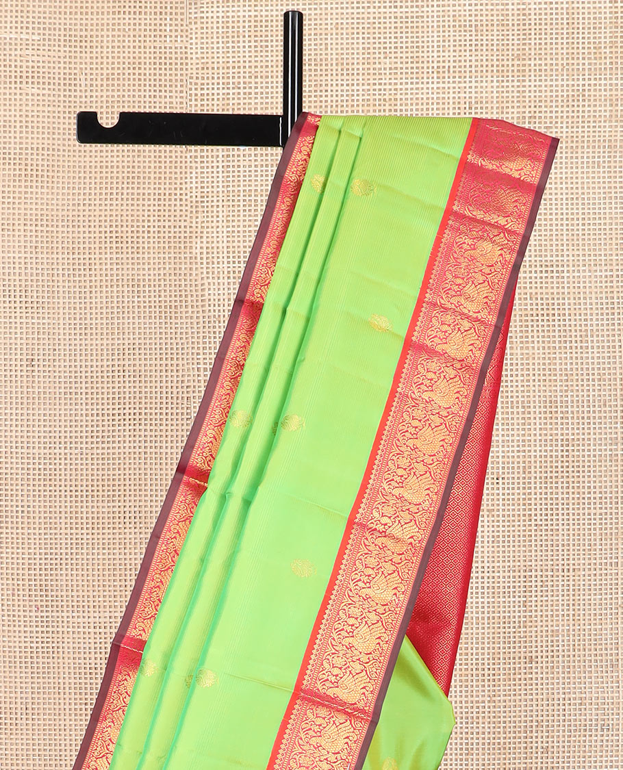 Green zari buttas Kanchipuram silk saree, contrast korvai border of thilakam mokku, muthu, and mayil designs, and jaal pallu
