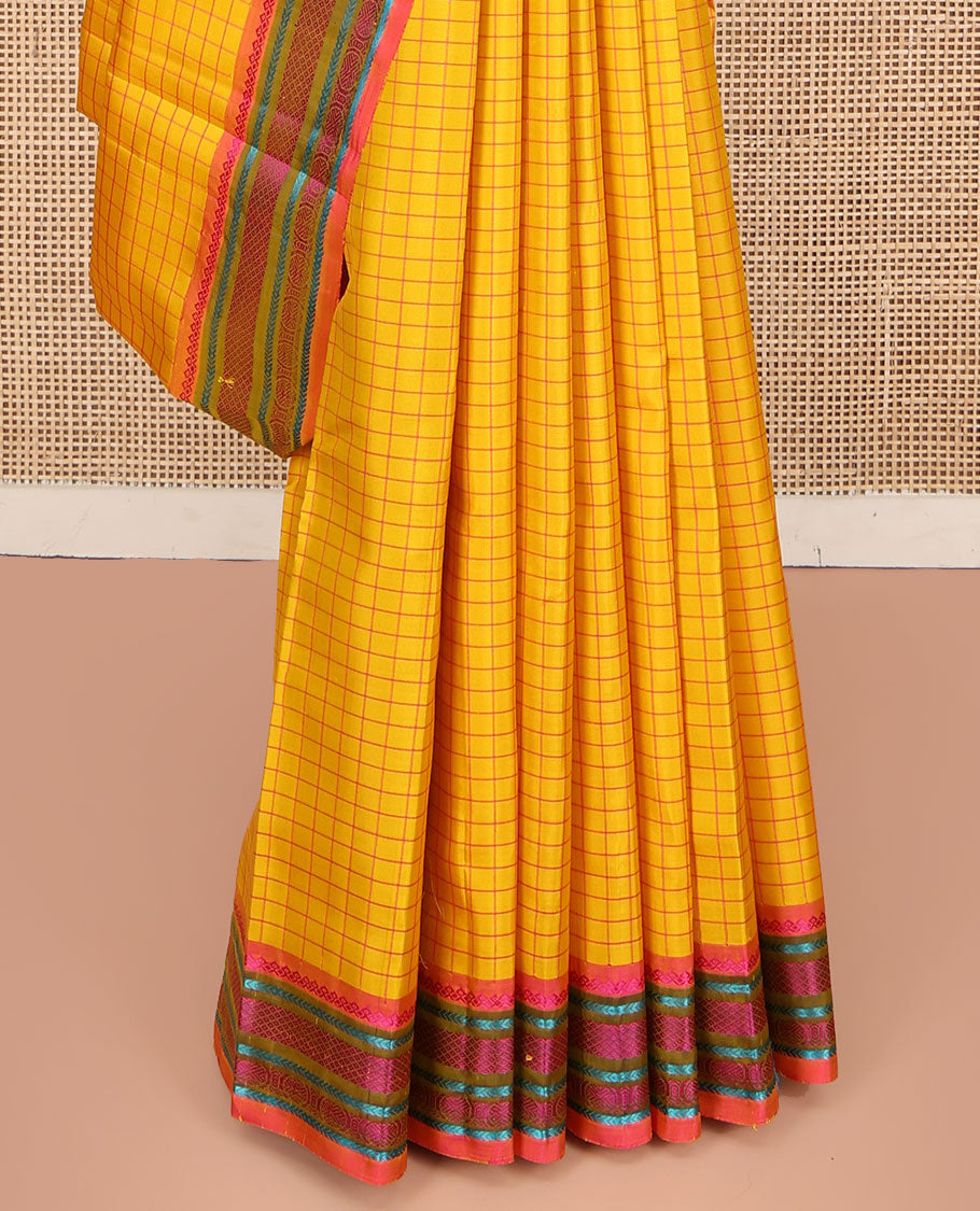 Yellow kanchipuram silk saree, subtly sparkled with checked design on its body, complemented by a contrast border of salngai, kathir, mayil kann, kathir, and rudraksham designs, a subtly striped pallu, and paired with a contrast blouse