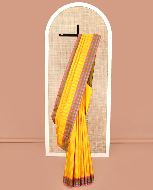 Yellow kanchipuram silk saree, subtly sparkled with checked design on its body, complemented by a contrast border of salngai, kathir, mayil kann, kathir, and rudraksham designs, a subtly striped pallu, and paired with a contrast blouse
