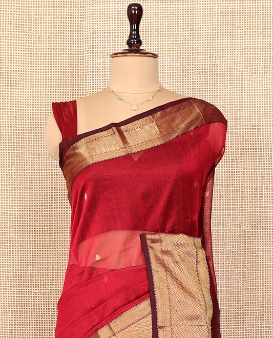 Red Maheshwari Cotton Saree, Adorned with Buttas All Over Its Body, Complemented by a Contrast Traditional Zari Woven Border, Pallu Mirrors the Same Design, and Paired with a Matching Blouse