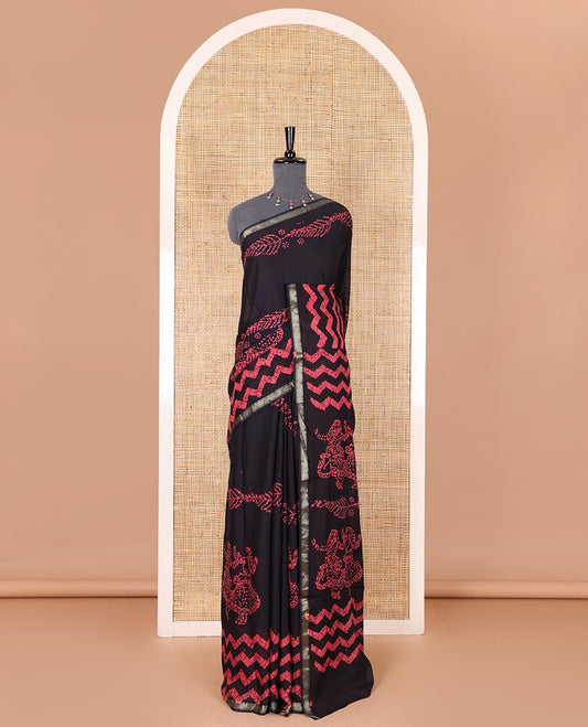 Ink blue wax batik-style zig-zag printed pure cotton saree, gold zari piping border, human figurines batik printed pallu, and a matching blouse