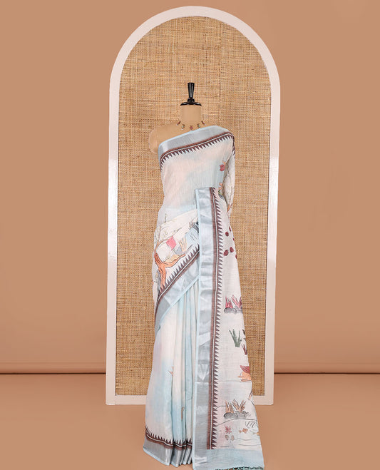 Sky blue nature-theme printed linen cotton saree features flora-fauna motifs, temple bavanji border, nature printed pallu, and a floral motif printed blouse