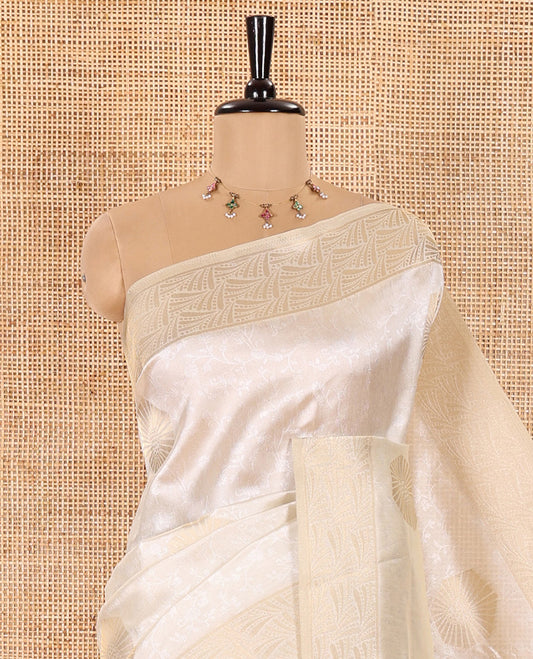 Cream Semi Tussar Saree Embellished with Floral Vine Embossed and Zari Buttas, Gleaming Border of Geometric Designs, Pallu Majestically Detailed with Geometric Designs in Zari, and Paired with a Matching Blouse