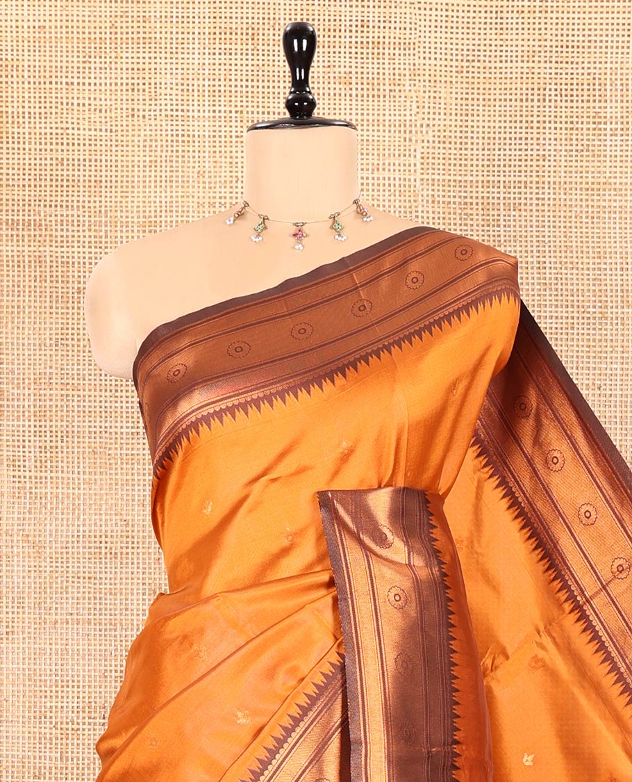Rust Orange Kanchi Silk Saree Adorned with Zari Buttas All Over Its Body, Complemented by Contrast Temple Motifs Woven Zari Border, Scintillating Pallu of Jaal Designs, and Paired with a Contrast Blouse