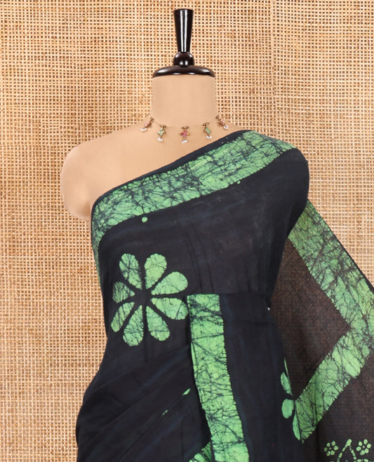 Navy Blue Mul Cotton Saree Enriched with Batik-Style Floral Motifs Printed All Over Its Body, Complemented by a Contrast Batik Printed Border, Pallu Mirrors the Same Batik Print, and Is Paired with a Matching Blouse