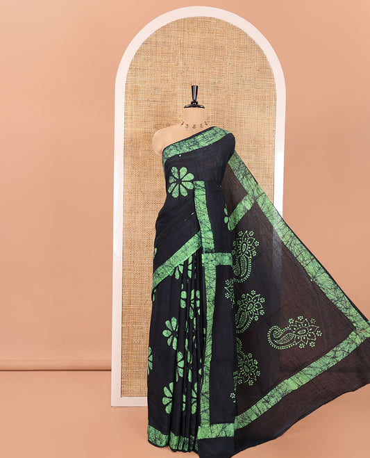 Navy Blue Mul Cotton Saree Enriched with Batik-Style Floral Motifs Printed All Over Its Body, Complemented by a Contrast Batik Printed Border, Pallu Mirrors the Same Batik Print, and Is Paired with a Matching Blouse